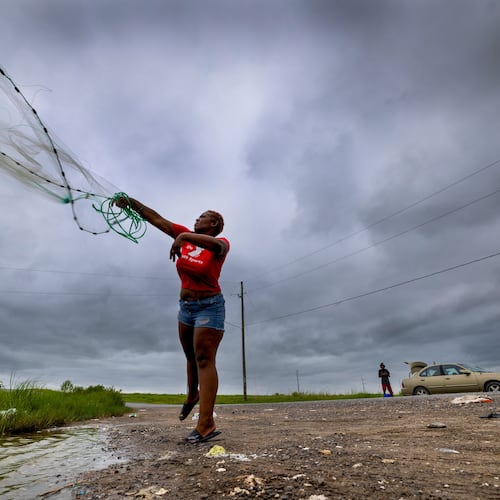 With skies darkening ahead of Tropical Storm Bertha, Latia Ancar practices her casting while she and a friend wait for the storm-driven tidal surge about 50 miles south of New Orleans on Wednesday, July 22, 2026, hoping it will bring more fish. (Chris Granger/The Times-Picayune/The New Orleans Advocate via AP)