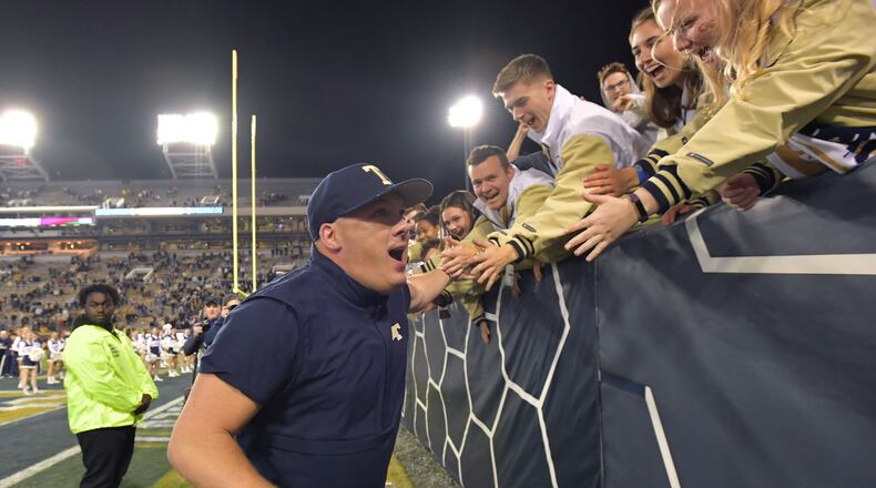 Back when slapping palms was OK: Georgia Tech head coach Geoff Collins celebrates with fans after beating North Carolina State last season. (Hyosub Shin / Hyosub.Shin@ajc.com)