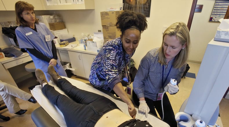Kristen Vaccarol (from left), Tigisty Girmay, and Kristy Lucarelli train to use a Fibroscan, a new piece of equipment that will help them track liver function and disease in the Women’s Interagency HIV Study. The test subject is fellow team member Dr. Paula Frew (she is not a patient). The Fibroscan performs the needed tests non-invasively, using ultrasound technology. Emory Center For AIDS Research researchers are partnering with SisterLove, Inc. and other metro Atlanta community based organizations to spread awareness and kick-off implementation of the Atlanta Women’s Interagency HIV Study.