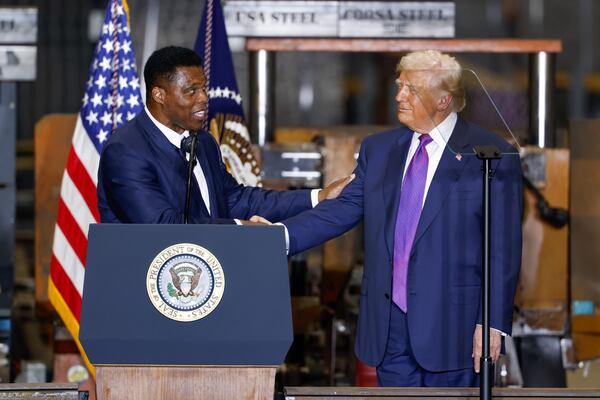 Herschel Walker (left), U.S. Ambassador to the Bahamas, took the stage with President Donald Trump at Coosa Steel in Rome on Thursday. (Arvin Temkar/AJC)