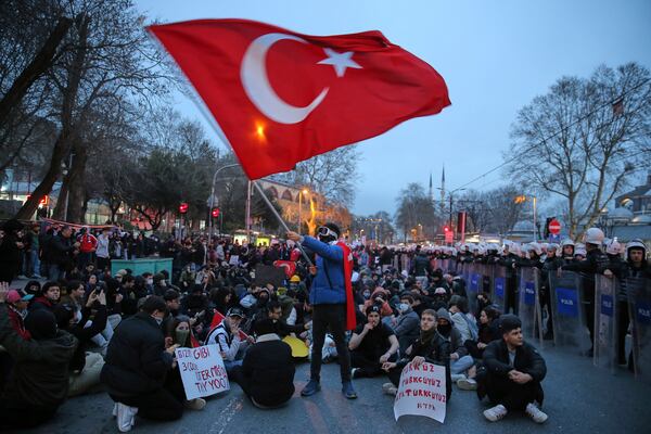 University students sit next to anti riot police officers in Istanbul, Turkey, Monday, March 24, 2025, during a protest after Istanbul's Mayor Ekrem Imamoglu was arrested and sent to prison. (AP Photo/Huseyin Aldemir)