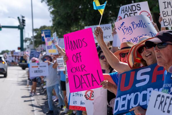 Activists protest President Donald Trump, who was a few miles away at his Trump National Golf Club, during a "Hands Off!" demonstration Saturday, April 5, 2025, in Palm Beach Gardens, Fla. (AP Photo/Alex Brandon)