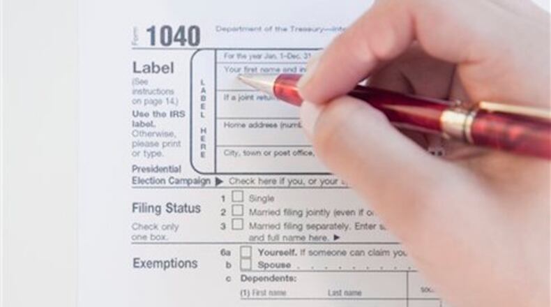 Woman completing tax form (Blend Images via AP Images)