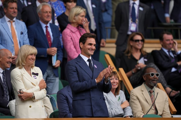 Tennis legend Roger Federer applauds after Serbia's Novak Djokovic beat Australia's Alex de Minaur during a fourth round men's singles match at the Wimbledon Tennis Championships in London, Monday, July 7, 2025. (AP Photo/Kin Cheung)