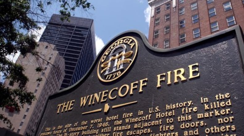 A historic marker stands in front of the old Winecoff Hotel (now the Ellis Hotel) with the Equitable Building soaring behind it on the left. The Winecoff burned on December 7, 1946, killing 119. It remains the country's worst hotel fire.