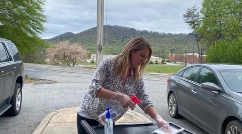 Shanda Ginn, owner and operator of Cleveland Academy in White County, disinfected a food cart she was using to distribute food to her enrolled children on March 31. She had closed her school a week earlier, after the state issued a coronavirus-related order that restricted the number of people in day care classrooms. She was still giving away “grab-n-go” meals to the parents who drove to her school. CONTRIBUTED BY MACY THOMPSON / CLEVELAND ACADEMY