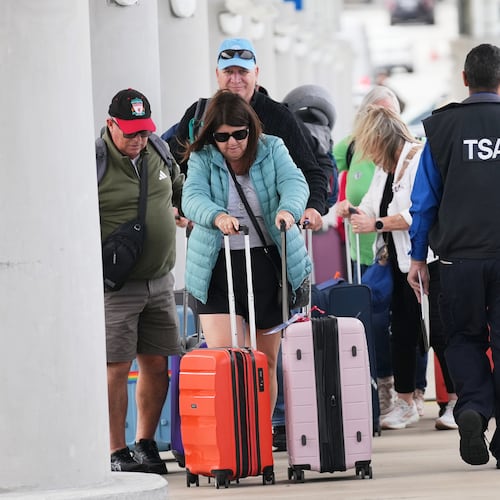 FILE - Travelers walk with their luggage past TSA agents at Fort Lauderdale-Hollywood International Airport, Nov. 13, 2025, in Fort Lauderdale, Fla. (AP Photo/Lynne Sladky, File)