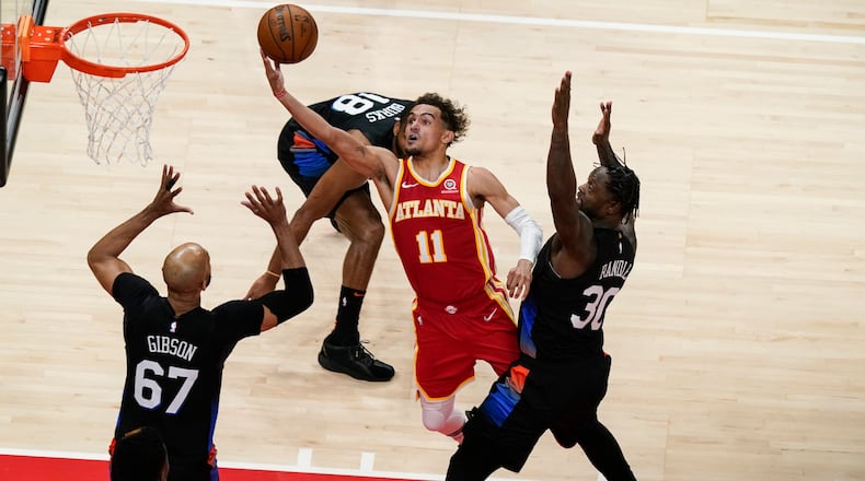 Atlanta Hawks' Trae Young (11) shoots against New York Knicks' Julius Randle (30) and Taj Gibson (67) during the first half in Game 3 of an NBA basketball first-round playoff series Friday, May 28, 2021, in Atlanta. (AP Photo/Brynn Anderson)