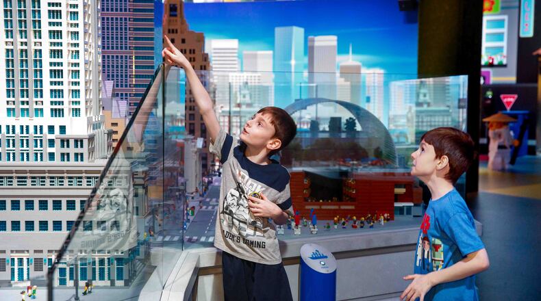 Eight-year-old twin brothers Patrick, left, and Dominic Basara, right, examine a Lego exhibit at the first sensory day for kids on the autism spectrum, at Legoland at the Plymouth Meeting Mall in Philadelphia on July 28, 2017. (Jessica Griffin/Philadelphia Inquirer/TNS)