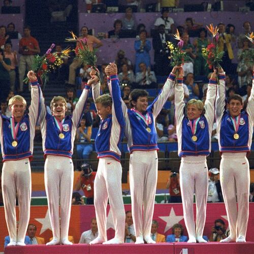 FILE - Members of the U.S. gymnastics team, from left: Bart Conner, Peter Vidmar, Jim Hartung, Mitch Gaylord, Scott Johnson and Tim Daggett, celebrate their gold medals as they stand on the winners' platform July 31, 1984 after they defeated world champion China to win the first U.S. gold medal in gymnastics in 80 years. (AP Photo/Lionel Cironneau, file)