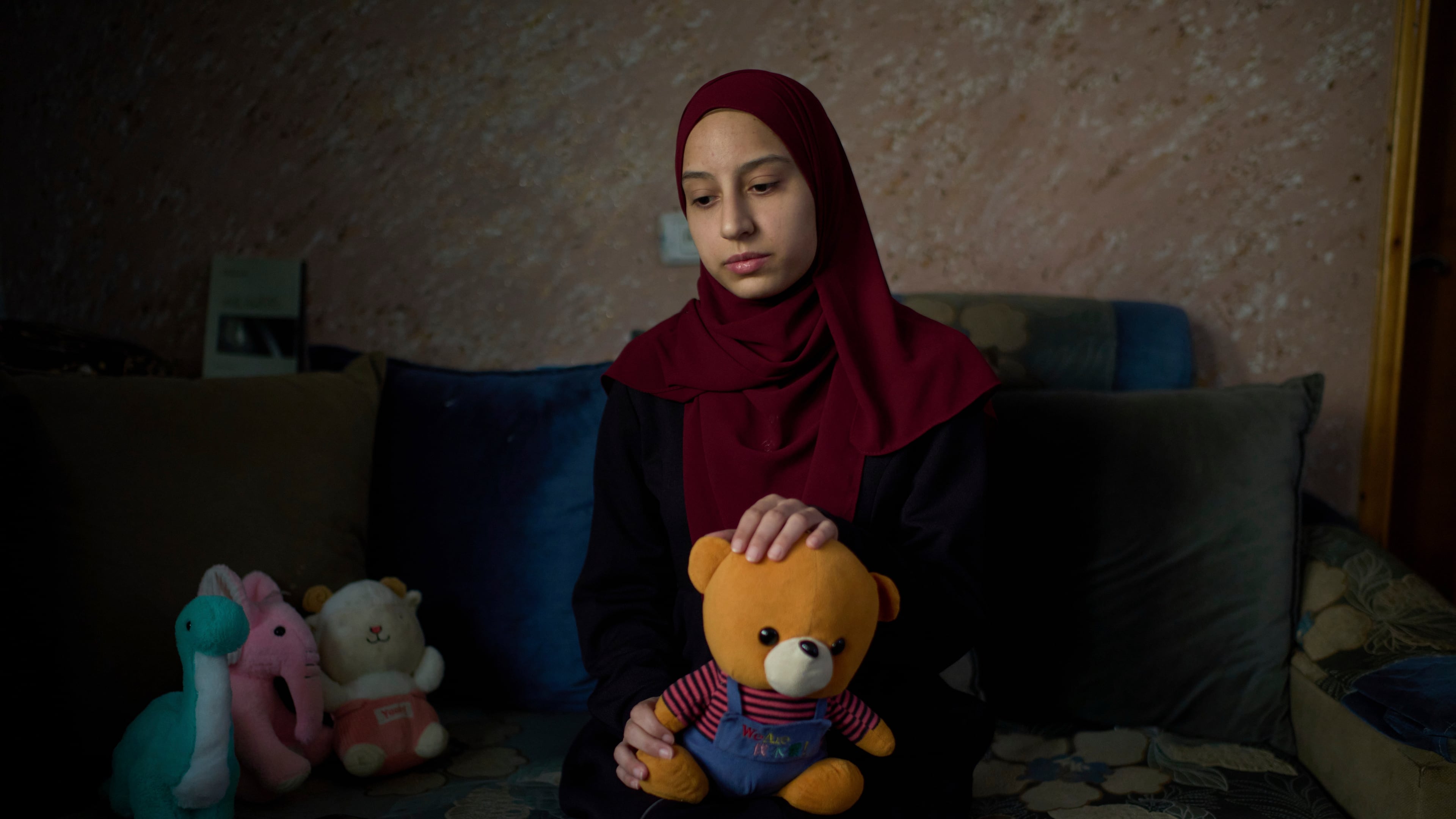 Tayma Asous, 26, holds the favorite toy of her 2-year-old daughter, Layla Al-Khatib, who was killed after being shot in the head by Israeli gunfire, at their home in the village of Muthallath ash-Shuhada, near the West Bank city of Jenin, March 11, 2025. (AP Photo/Leo Correa)