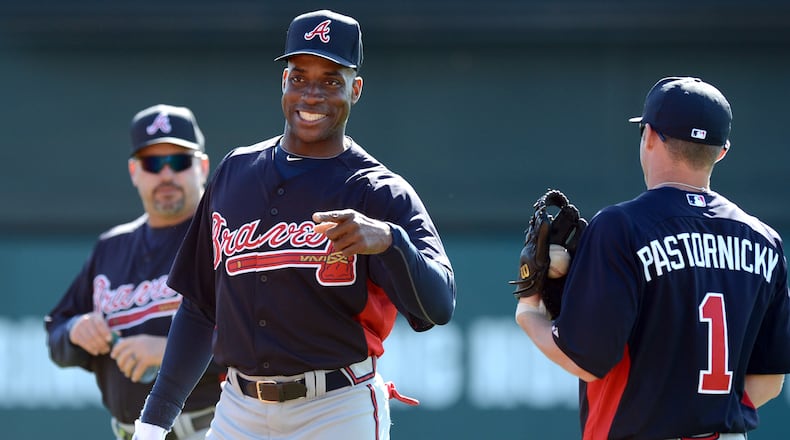 Former Braves Fred McGriff first baseman talks with infielder Tyler Pastornicky during fielding drills.