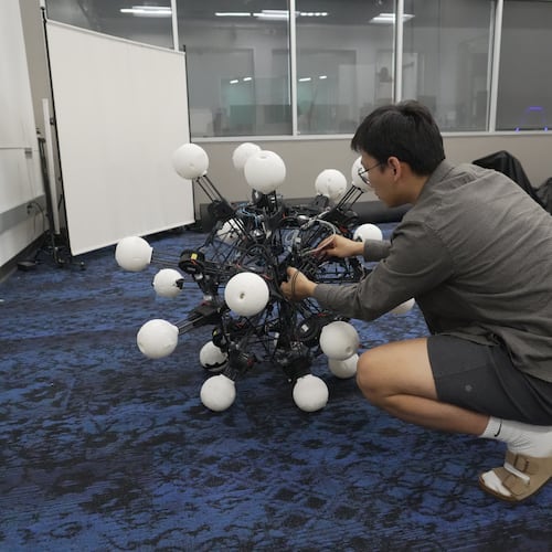Jiaxun Liu, a Ph.D. student, works on a robot named Argus at Duke University's General Robotics Lab in Durham, N.C., Tuesday, May 26, 2026. (AP Photo/Allen G. Breed)