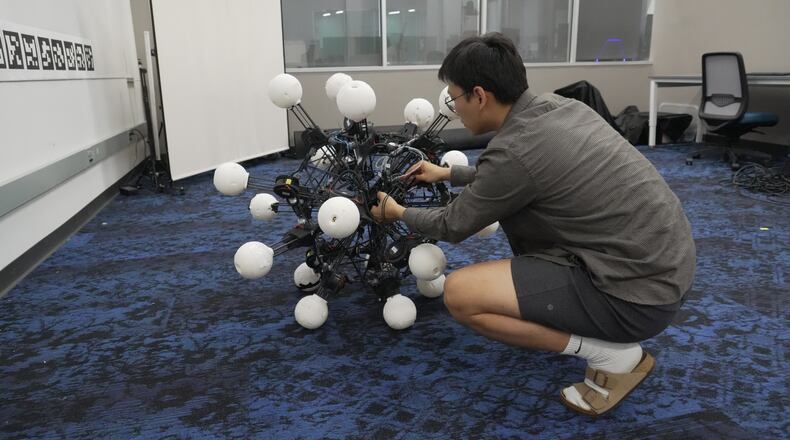 Jiaxun Liu, a Ph.D. student, works on a robot named Argus at Duke University's General Robotics Lab in Durham, N.C., Tuesday, May 26, 2026. (AP Photo/Allen G. Breed)