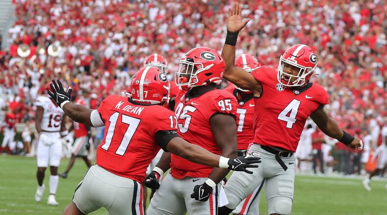 Georgia defenders Nakobe Dean (from left), Devonte Wyatt, and Nolan Smith celebrate after Wyatt sacked Arkansas quarterback KJ Jefferson during the first quarter in a 37-0 shutout over Arkansas on Saturday, Oct. 2, 2021, in Athens. Curtis Compton / Curtis.Compton@ajc.com
