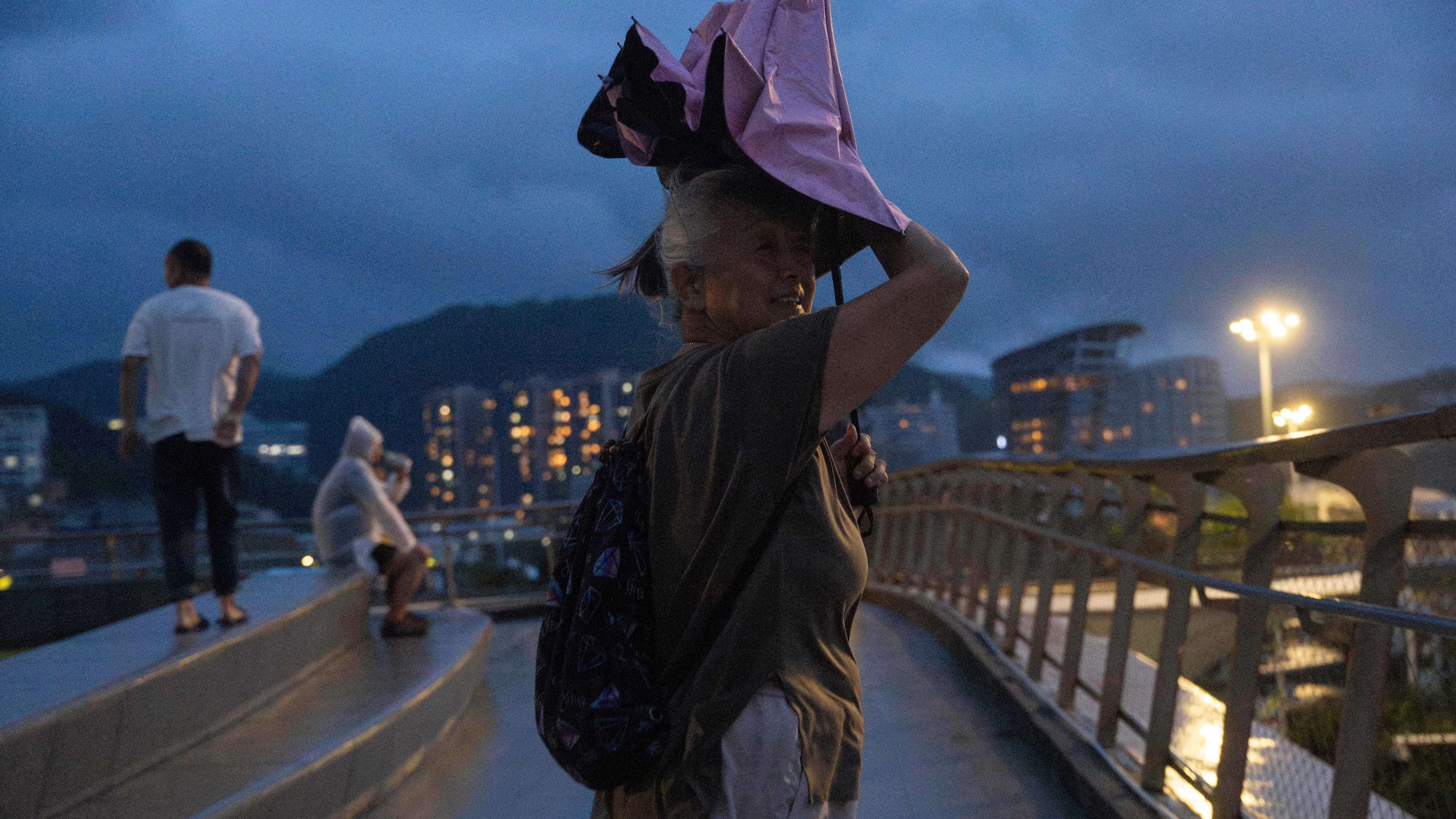 An elderly woman shelters from the rain in the aftermath of Super Typhoon Ragasa in Shenzhen in southern China's Guangdong province on Wednesday, Sept. 24, 2025. (AP Photo/Ng Han Guan)