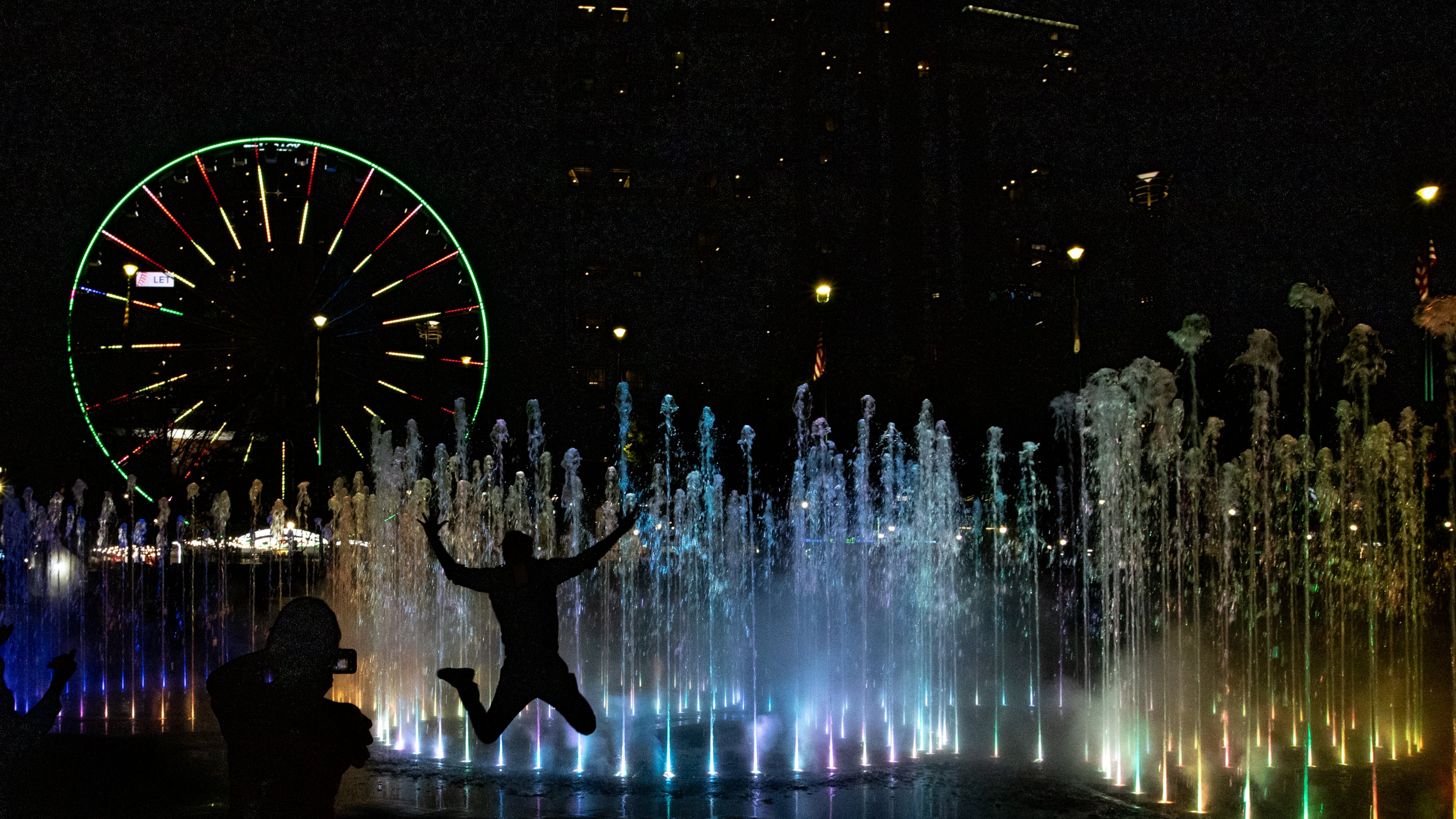 Anders Leverton, in town for a conference from Texas, visits the Fountain of Rings at Centennial Olympic Park on Thursday, March 27, 2025 after a $3.5 million renovation updating the fountain show with new songs, new pumps and new technology.  (Jenni Girtman for The Atlanta Journal-Constitution)