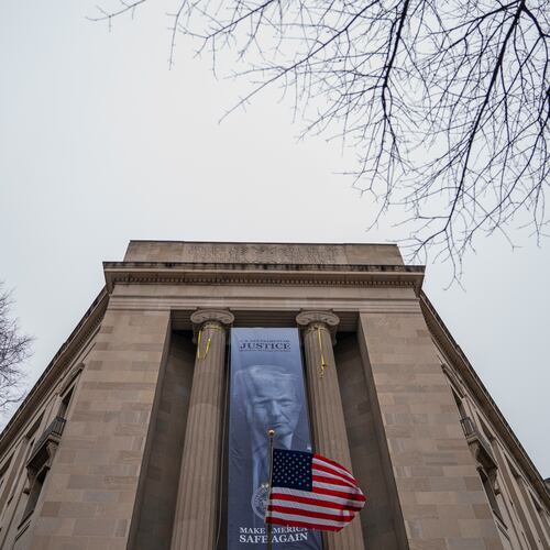 A banner showing President Donald Trump is hung from the Department of Justice, Thursday, Feb. 19, 2026, in Washington. (AP Photo/Allison Robbert)