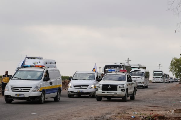 Syrian Bedouin families ride in a convoy led by Red Crescent vehicles in Busra al-Harir, heading to Daraa after being evacuated from Sweida following more than a week of violent clashes, Monday, July 21, 2025. (AP Photo/Malek Khattab)