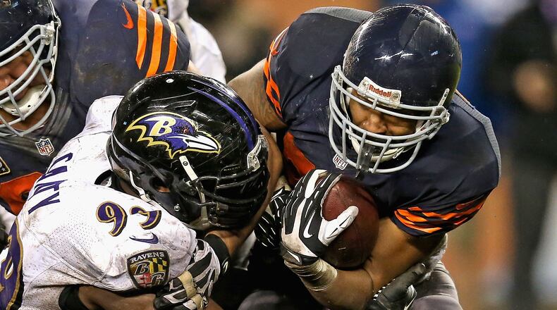 Matt Forte, formally of the Chicago Bears, is hit by Chris Canty #99 of the Baltimore Ravens at Soldier Field on November 17, 2013 in Chicago, Illinois. The Bears and Ravens face off Thursday, August 2, 2018 in the first NFL preseason game in Canton, Ohio.