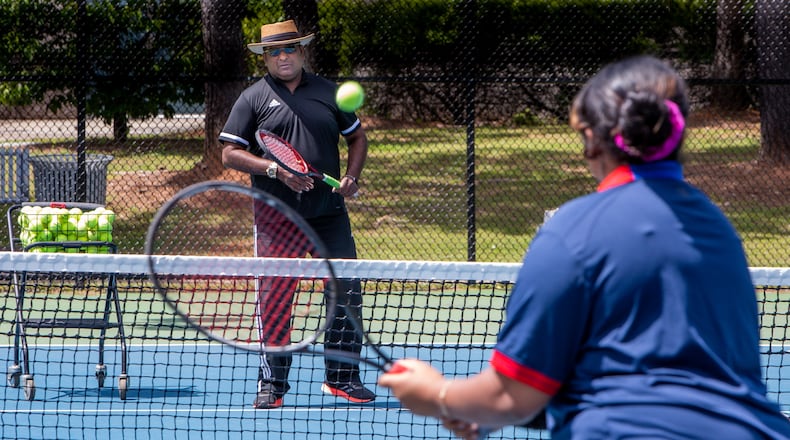 Tennis instructor Francis Ali trains his daughter Brianna during a session at the Lucky Shoals Park tennis courts in Norcross. He lost both of his legs in a bad traffic accident several years ago. Phil Skinner/For The Atlanta Journal-Constitution