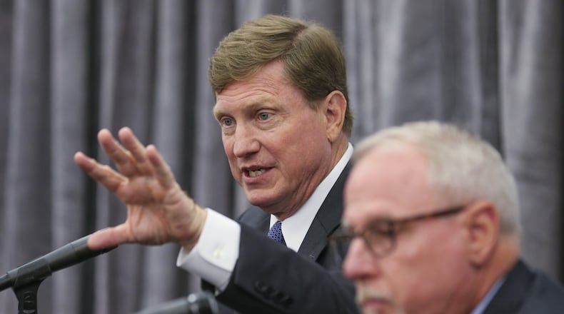 Tom Fanning (left) Southern Company chairman and CEO, shown here at a press conference with former AGL Resources CEO John Somerhalder. JOHN SPINK / JSPINK@AJC.COM