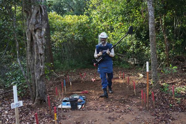 Vilvaraj Vinothan who works for a demining agency, uses a metal detector to scan for unexploded explosive devices in a contaminated mining area in Mankulam, Sri Lanka, Wednesday, April 2, 2025. (AP Photo/Eranga Jayawardena)