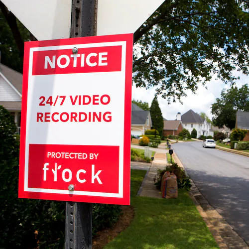 This sign greets people driving into neighborhoods with Flock Safety cameras.
