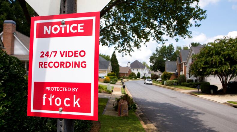 This sign greets people driving into neighborhoods with Flock Safety cameras.