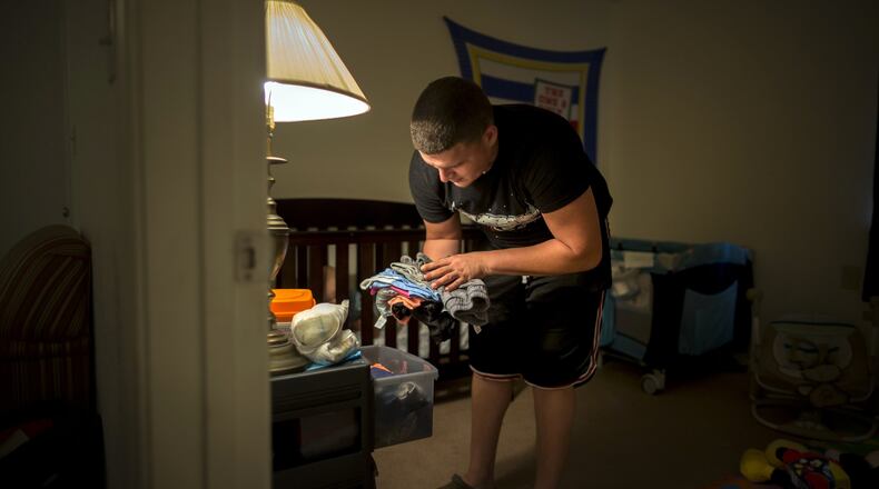 Kenneth Caban Gonzalez puts away clean laundry for his son Noah. The Hinesville resident does not have a Georgia drivers license and has had a tough time finding a job. He does all he can around the house in support of his family while he’s unemployed. (AJC Photo/Stephen B. Morton)