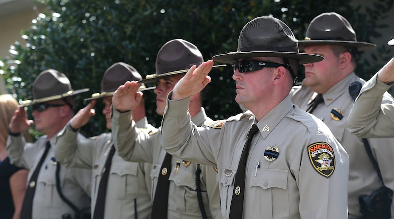 Members of the Pickens County Sheriffs Office salute the procession during the funeral of Polk County police Detective Kristen Hearne. A House bill would create a state-run peer-counseling program for first responders throughout the state to seek help with emotional concerns. Curtis Compton/ccompton@ajc.com
