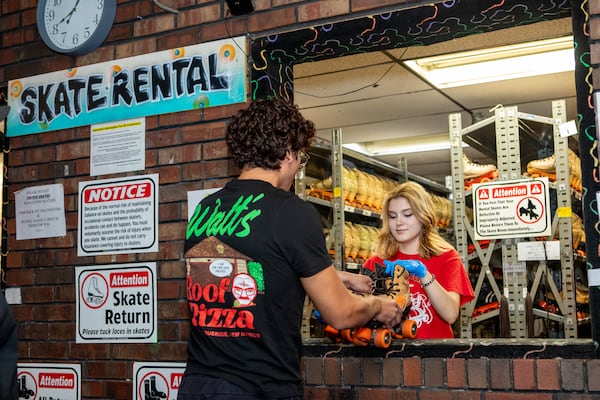Tuna Tunc works the rental counter at Skate Along USA in Lilburn during the second to last adult night at the roller skating rink Wednesday, Aug. 13, 2025. It will close permanently on Aug. 24 after 47 years in business. (Jenni Girtman for the AJC)