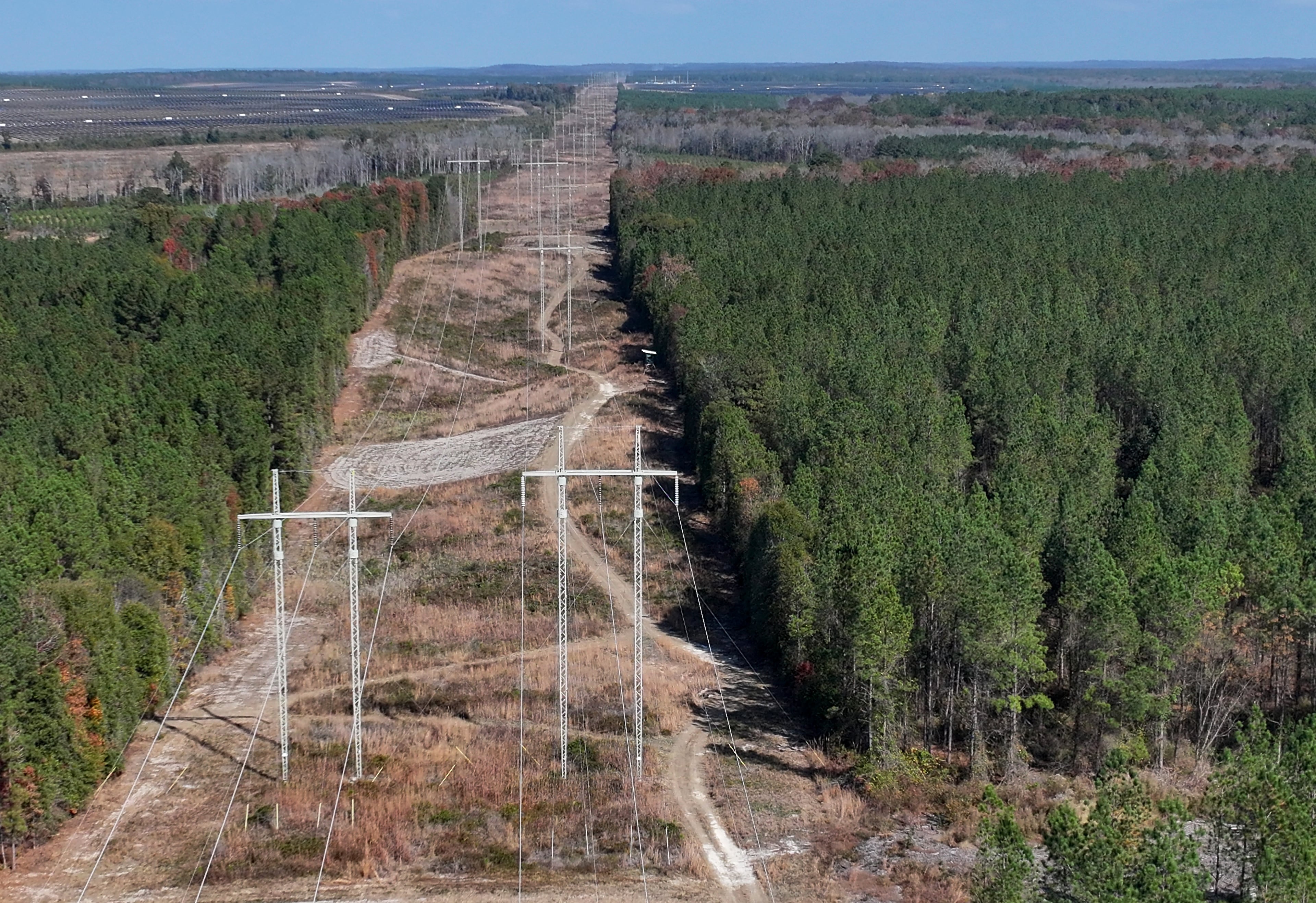 Aerial photo shows high voltage power lines running near the proposed data center site (right) and Twiggs Solar solar farm site (background), Wednesday, Nov. 19, 2025, in Dry Branch. (Hyosub Shin/AJC)