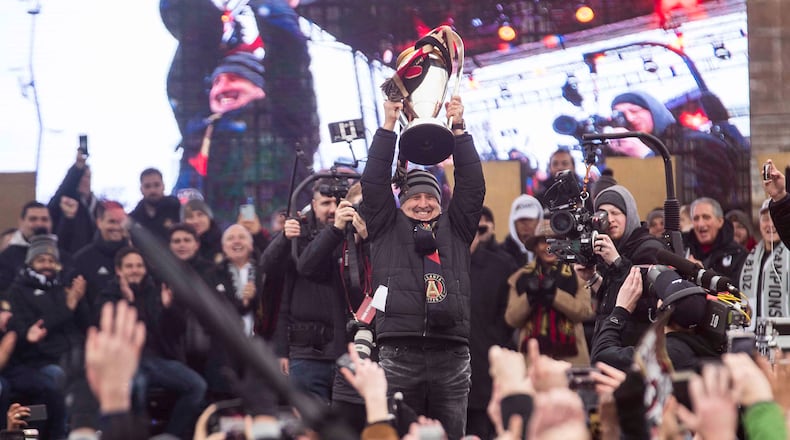 Atlanta United head coach Gerardo "Tata" Martino is applauded as he raises the Major League Soccer Championship trophy during the Atlanta United victory rally at the Home Depot Backyard Lot, Dec. 10, 2018. The Atlanta United became the second major league team in Georgia to win a championship title. The Atlanta United beat the Portland Timbers during the MLS Championship that was hosted at Mercedes-Benz Stadium, Saturday, December 8. (ALYSSA POINTER/ALYSSA.POINTER@AJC.COM)
