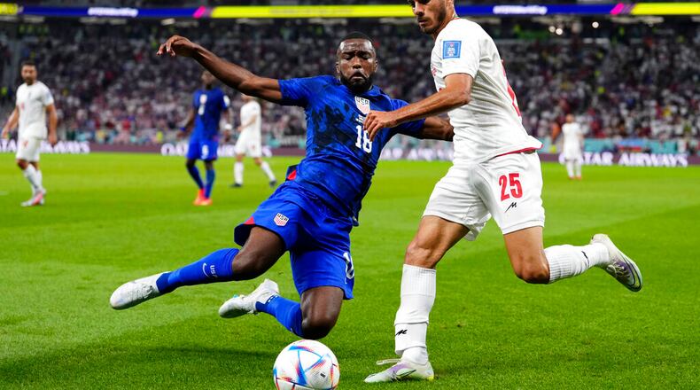 Shaq Moore of the United States (left) challenges Iran's Abolfazl Jalali during the World Cup Group B soccer match between Iran and the U.S. in Doha, Qatar. (Manu Fernandez/AP 2022)