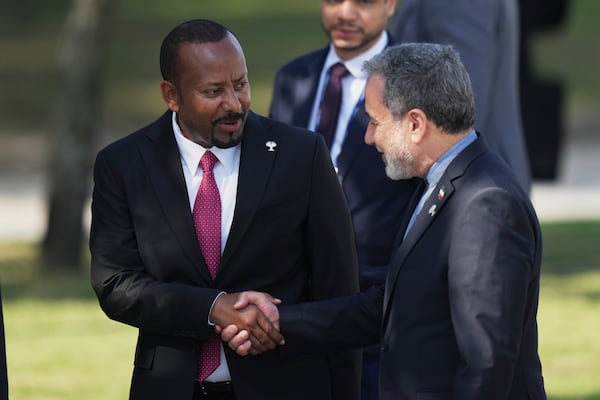 Prime Minister of the Federal Democratic Republic of Ethiopia Abiy Ahmed Ali, left, shakes hands with Iranian Foreign Minister Abbas Araghchi during the 17th annual BRICS summit in Rio de Janeiro, Sunday, July 6, 2025. (AP Photo/Silvia Izquierdo)