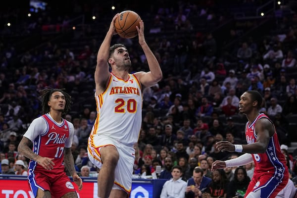 Atlanta Hawks' Georges Niang (20) goes up to shoot against Philadelphia 76ers' Jalen Hood-Schifino (17) and Lonnie Walker IV during the first half of an NBA basketball game Friday, April 11, 2025, in Philadelphia. (AP Photo/Matt Rourke)