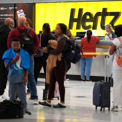 Travelers wait in line at the rental car center at George Bush Intercontinental Airport on Friday, Nov. 7, 2025, in Houston. (AP Photo/Ashley Landis)
