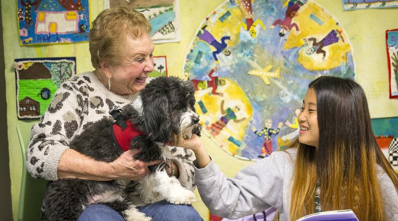 Cynthia Zeldin (left) allows Global Village Project student Mu Doe (right) to pet Lily, a registered therapy dog, during their reading time at the Global Village Project school in Decatur in November 2019. The Global Village Project is one of about 20 nonprofits to receive a grant from the Atlanta Women’s Foundation, as the organization announced the investment of $1.418 million to nonprofits providing programmatic support to women and girls in Metro Atlanta. (Alyssa Pointer/AJC)