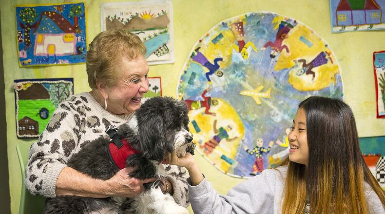 Cynthia Zeldin (left) allows Global Village project student Mu Doe (right) (last name withheld), 15, to pet Lily, a registered therapy dog, during their reading time at the Global Village Project school in Decatur. (ALYSSA POINTER/ALYSSA.POINTER@AJC.COM)