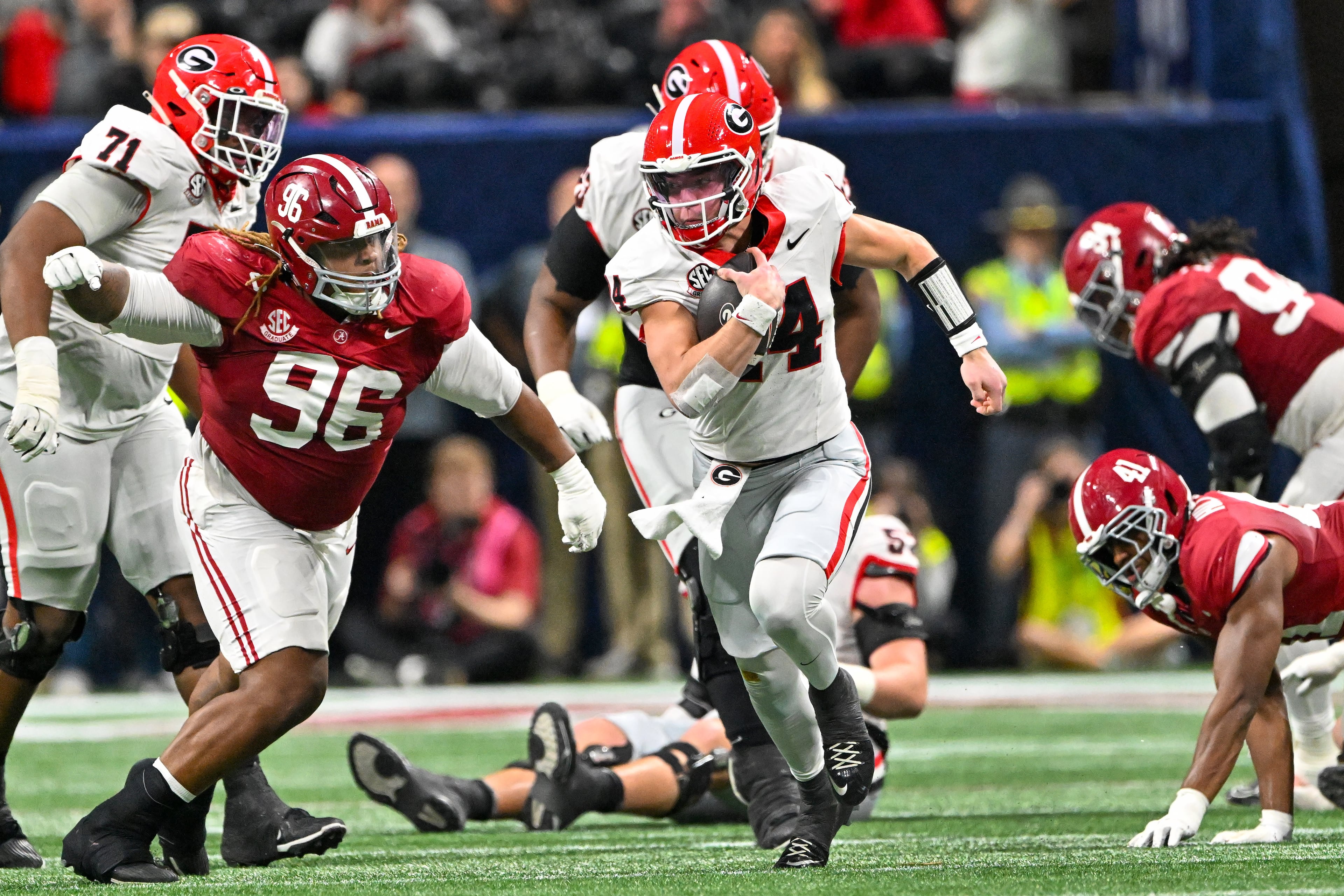 Georgia quarterback Gunner Stockton (14) runs a keeper play against Alabama defensive lineman Tim Keenan III (96) during the third quarter of the SEC Championship game at Mercedes-Benz Stadium, Saturday, Dec. 6, 2025, in Atlanta. (Hyosub Shin / AJC)