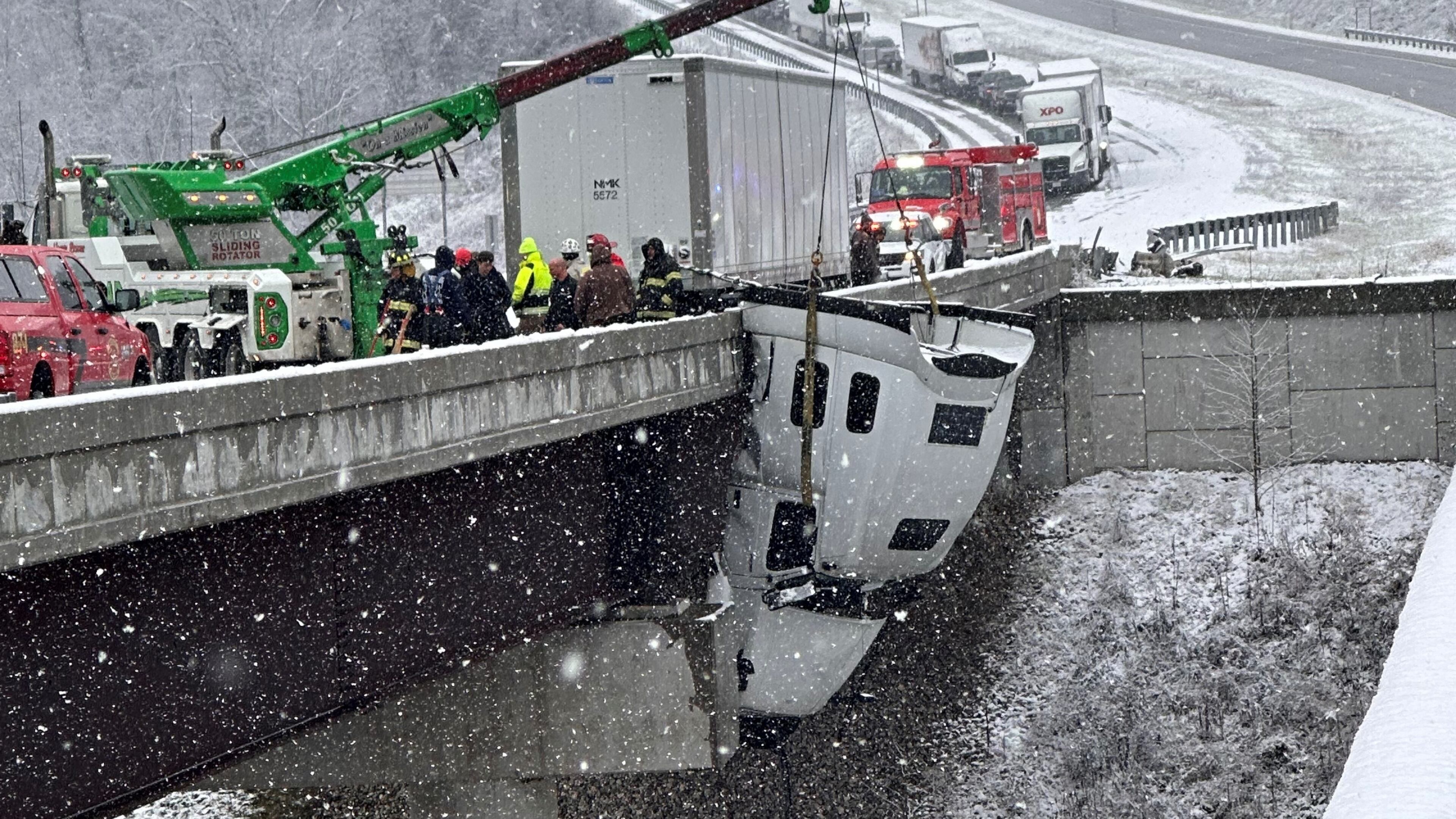This photo provided by Vickie Flora shows crews working to remove a truck cab dangling from a bridge along U.S. Route 35 after it crashed in icy conditions Tuesday, Dec. 2, 2025, in Southside, W.Va. (Vickie Flora via AP)