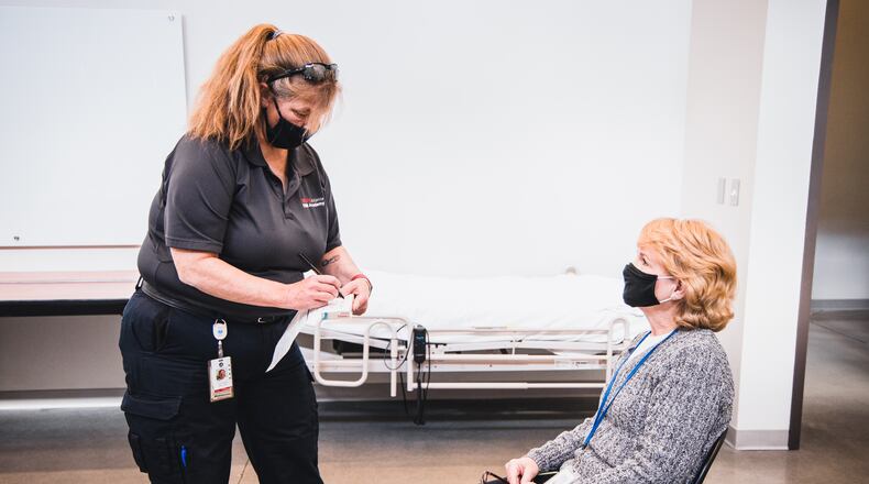 A healthcare worker takes information from Sandra Roth, a Dunlieth Elementary School teacher, before she gets the COVID-19 vaccine. Credit: Natalie Roush/Marietta City Schools