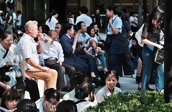 People take shelter outdoors after an earthquake shook nearby high-rises in Bangkok, Thailand, Friday, March 28, 2025. (AP Photo/David Cohen)