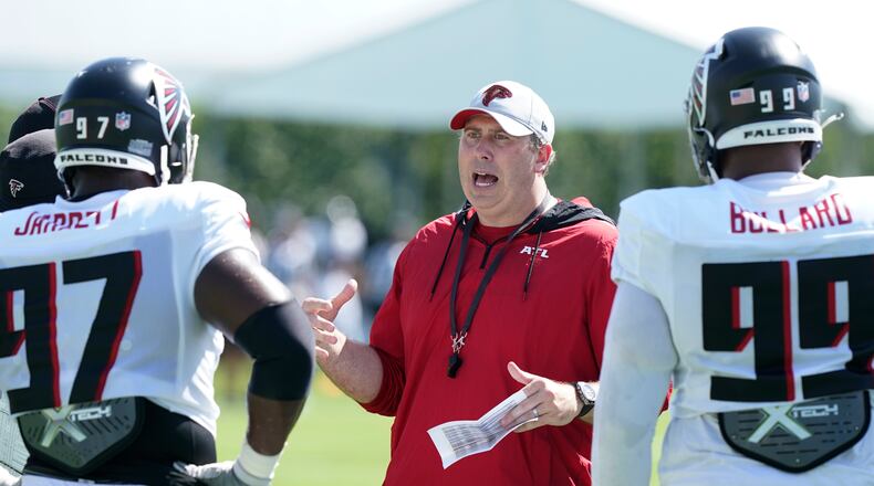 Atlanta Falcons head coach Arthur Smith talks to defensive lineman Grady Jarrett (97) and Jonathan Bullard (99) during a NFL football practice, Thursday, Aug. 19, 2021, in Miami Gardens, Fla. (AP Photo/Marta Lavandier)