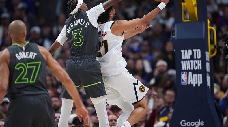 Minnesota Timberwolves forward Jaden McDaniels, left, tries to block a shot by Denver Nuggets guard Jamal Murray in the second half in Game 1 of a first-round NBA playoffs basketball series, Saturday, April 18, 2026, in Denver. (AP Photo/David Zalubowski)