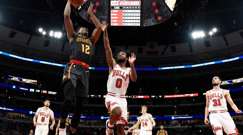 Hawks forward De'Andre Hunter (12) goes to the basket as Chicago Bulls guard Coby White (0) defends. (AP Photo/David Banks)