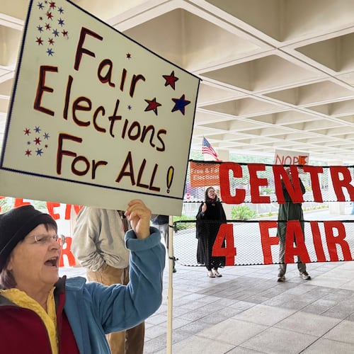 Protestors opposed to mid-decade redistricting wave signs outside of Florida’s Capitol building in Tallahassee, Fla. on Dec. 4, 2025. (AP Photo/Kate Payne)