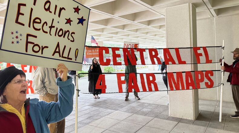 Protestors opposed to mid-decade redistricting wave signs outside of Florida’s Capitol building in Tallahassee, Fla. on Dec. 4, 2025. (AP Photo/Kate Payne)