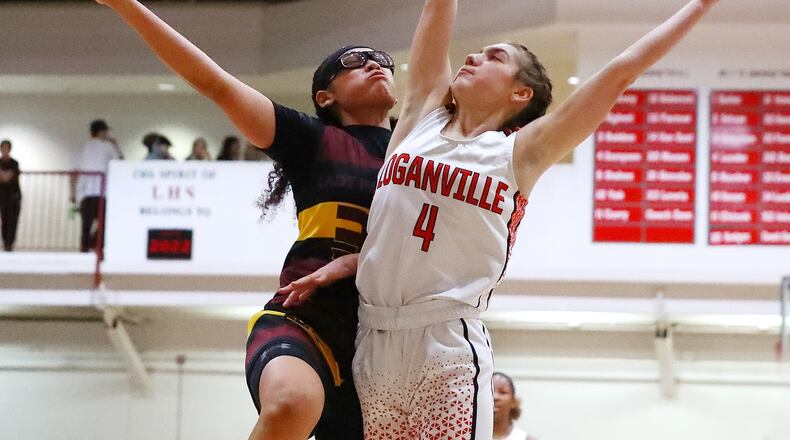 Forest Park guard Yasmine Allen goes to the basket for two against Loganville guard Rivers Sampson in their high school basketball tournament game Wednesday in Loganville. (Curtis Compton / Curtis.Compton@ajc.com)